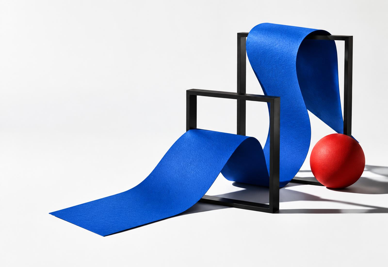 Blue ribbon sculpture weaving through black frames